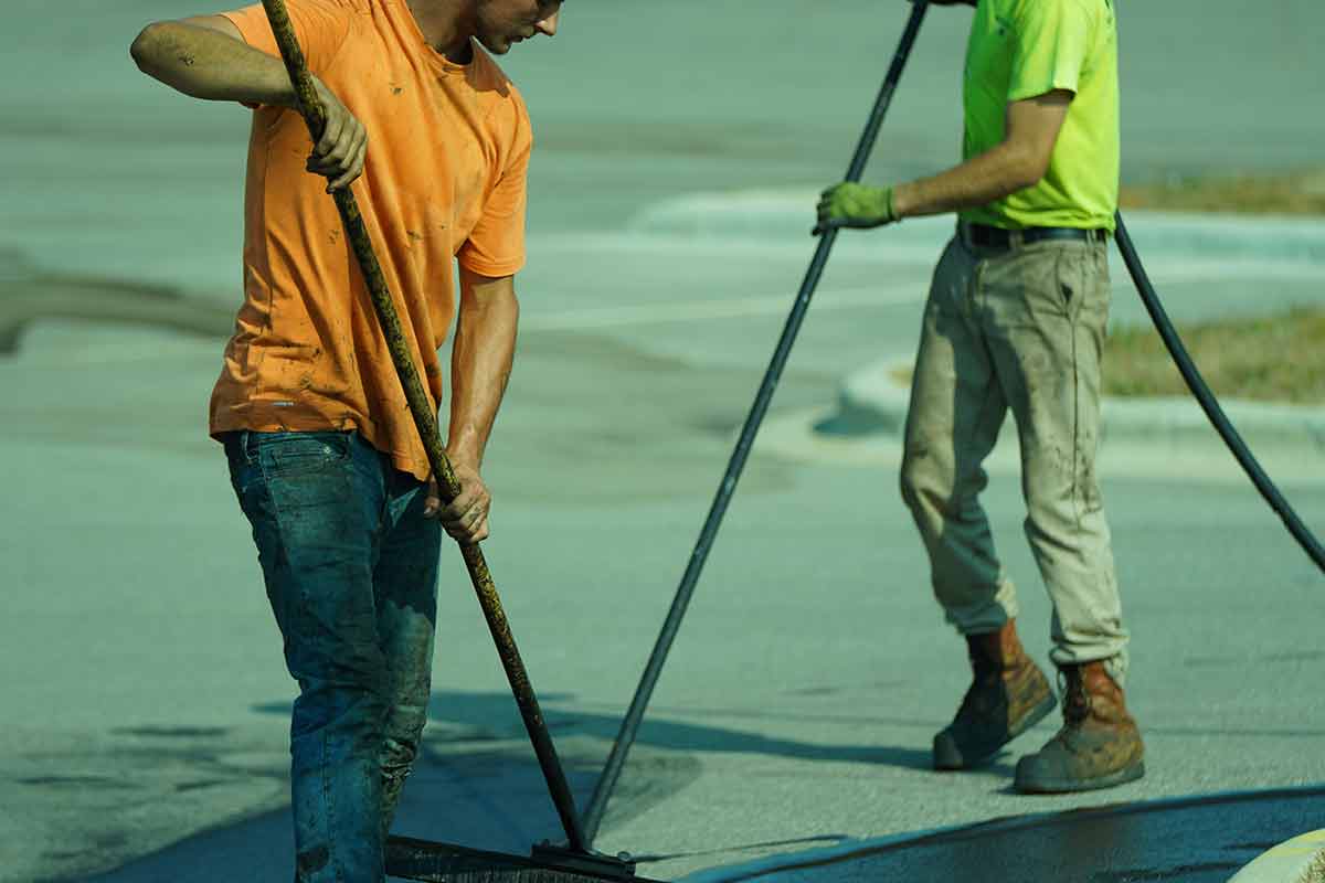 Sealcoating crew applying fresh coat to a commercial parking lot